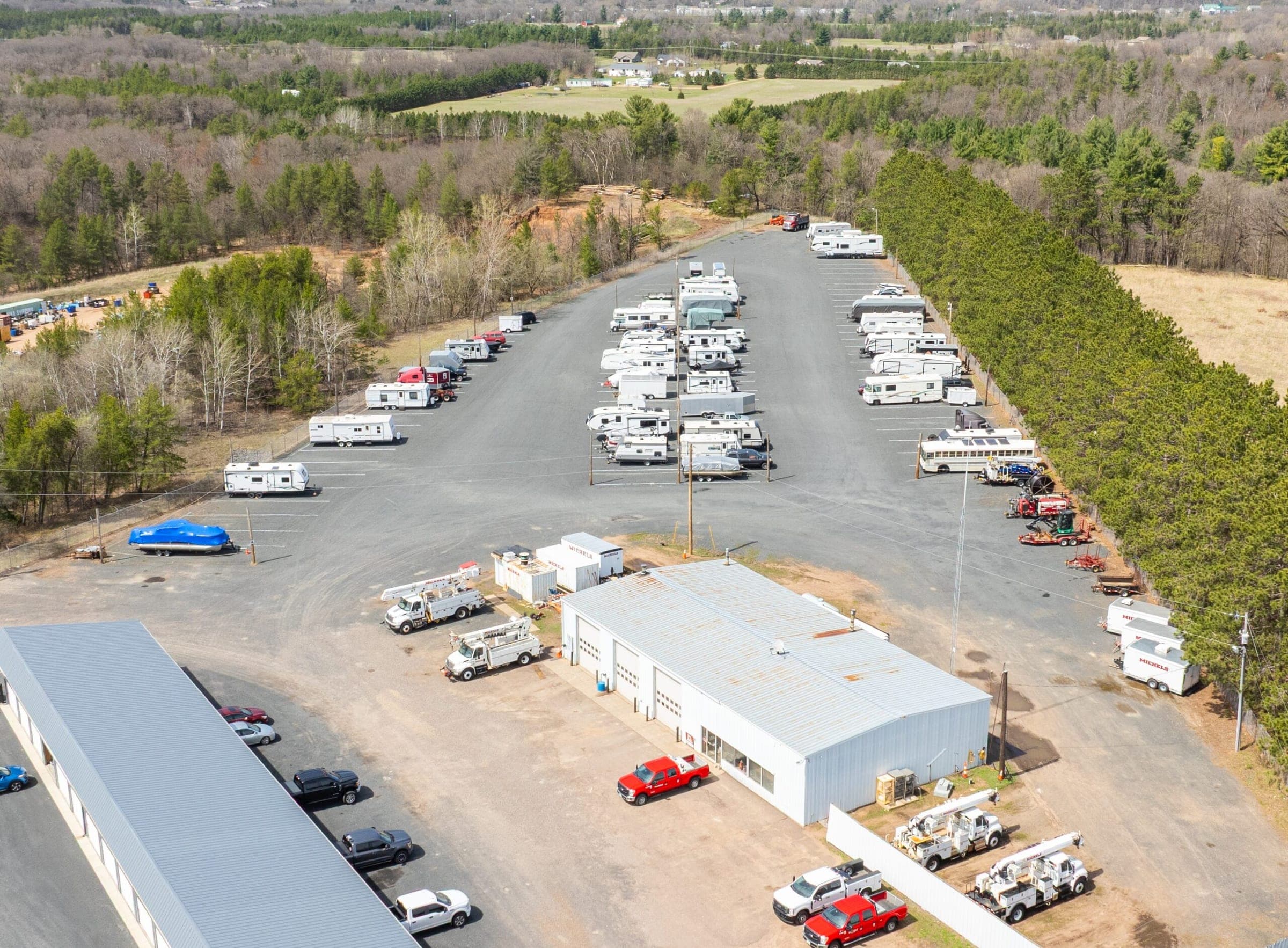 Aerial view of RVs, campers, and boats parked on the gated outdoor lot at Precision One Storage